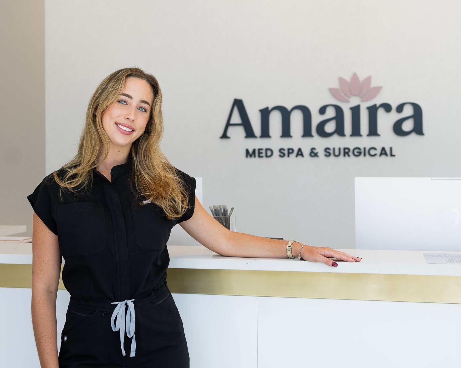 A smiling Amaira team member at the Delray Beach reception desk